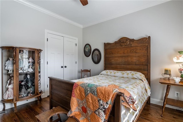 bedroom featuring baseboards, a ceiling fan, dark wood-type flooring, crown molding, and a closet