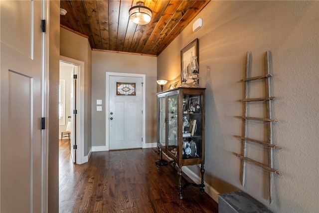 entrance foyer with wooden ceiling, baseboards, dark wood finished floors, and crown molding