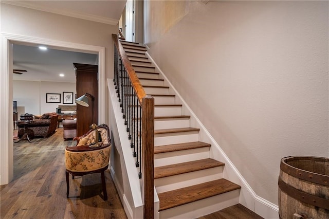 stairs featuring recessed lighting, crown molding, and wood finished floors