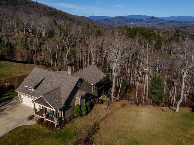 birds eye view of property featuring a forest view and a mountain view