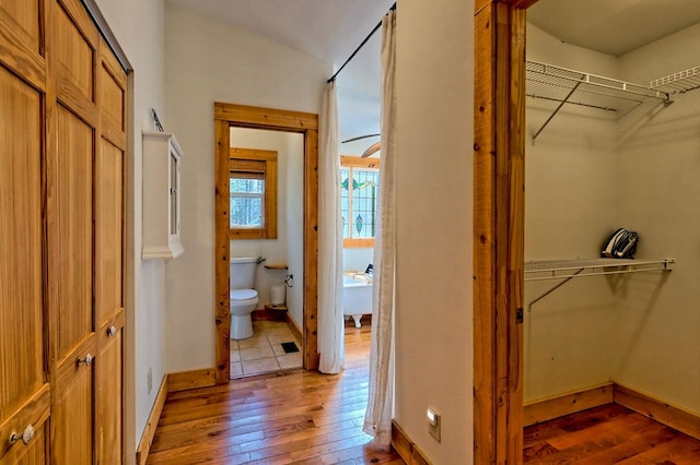 hall with hardwood / wood-style flooring and baseboards