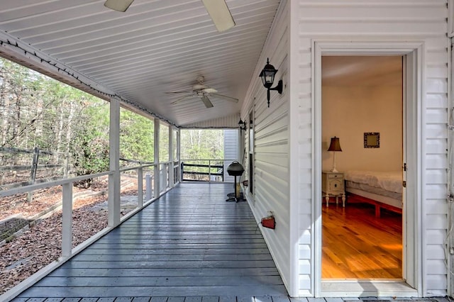 wooden terrace with covered porch, ceiling fan, and fence