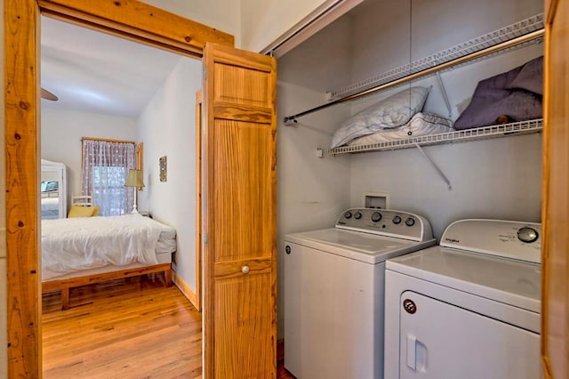 laundry area featuring laundry area, light wood-style flooring, and washer and clothes dryer