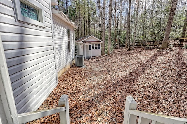 view of yard with fence, cooling unit, and an outdoor structure