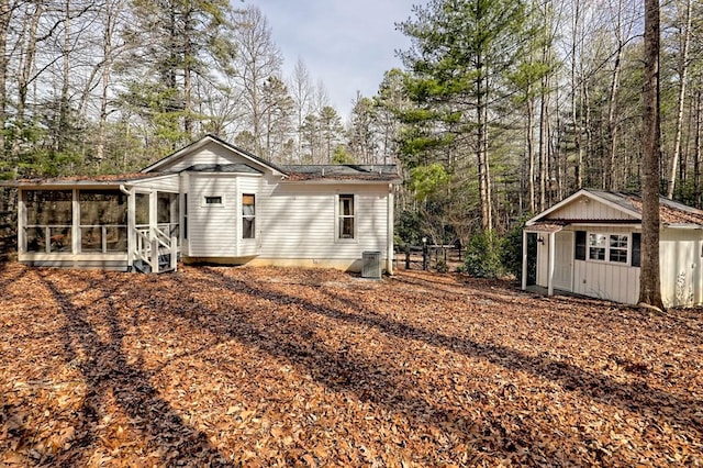 exterior space with a sunroom, an outdoor structure, and central AC unit