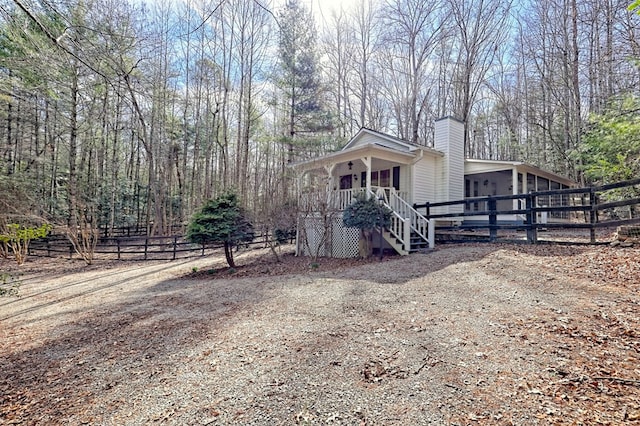 view of side of property with a chimney and fence