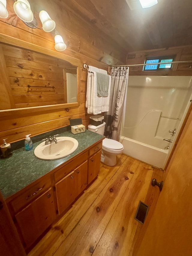 135 Tomahawk Trl, Blue Ridge, GA 30513 - full bath featuring hardwood / wood-style flooring, toilet, vanity, shower / bathtub combination with curtain, and wood walls