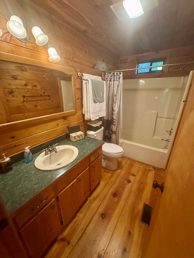 135 Tomahawk Trl, Blue Ridge, GA 30513 - bathroom featuring wood-type flooring, toilet, vanity, shower / tub combo with curtain, and wooden walls
