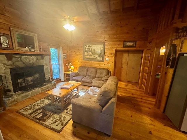135 Tomahawk Trl, Blue Ridge, GA 30513 - living room featuring wood-type flooring, a stone fireplace, and wood walls