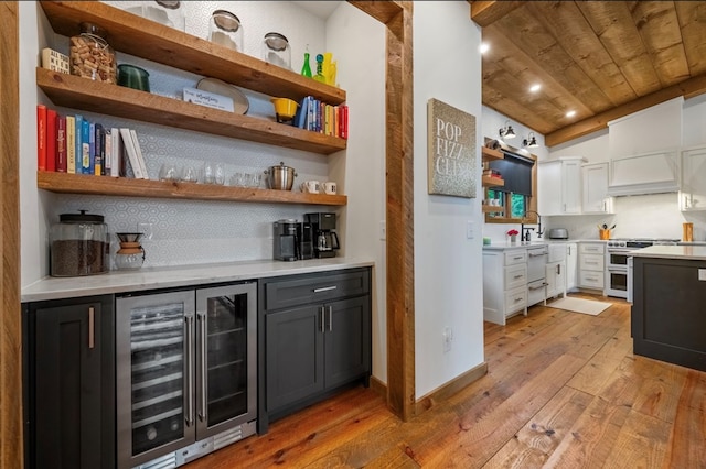 bar with white cabinets, light hardwood / wood-style floors, wooden ceiling, and wine cooler