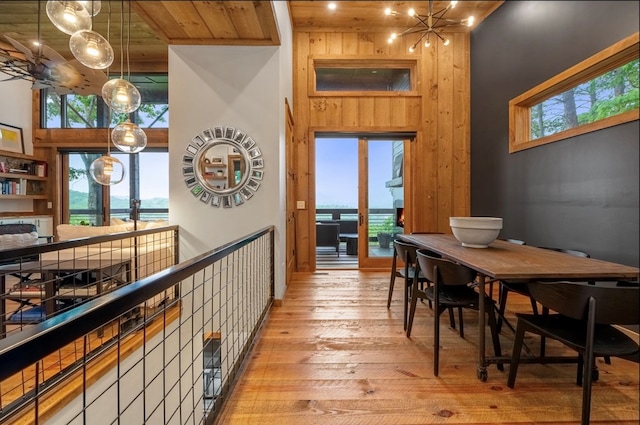 interior space featuring pendant lighting, light hardwood / wood-style floors, a wealth of natural light, and a water view