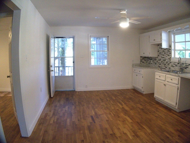 kitchen featuring dark hardwood / wood-style flooring, sink, white cabinets, and a healthy amount of sunlight