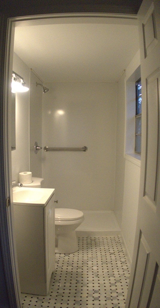 bathroom featuring a shower, vanity, tile patterned floors, and toilet