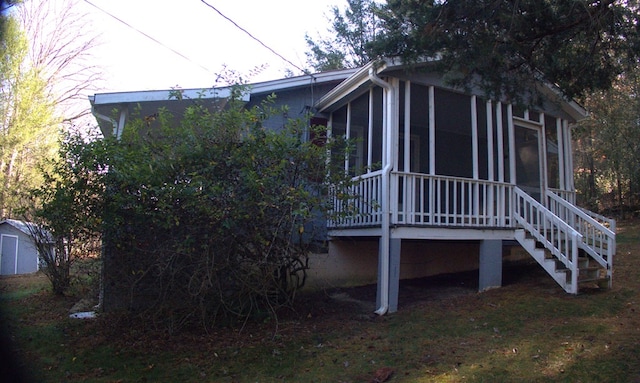 back of property with stairs and a sunroom