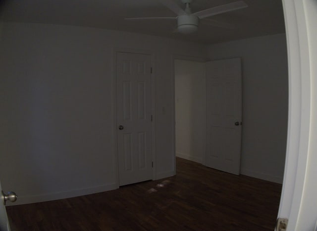 unfurnished bedroom with ceiling fan and dark hardwood / wood-style floors