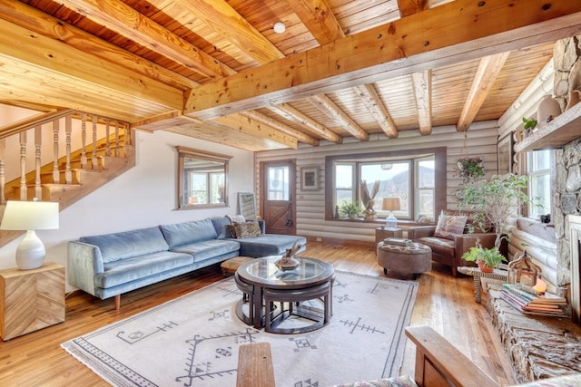 living room with beam ceiling, light hardwood / wood-style flooring, rustic walls, and wooden ceiling