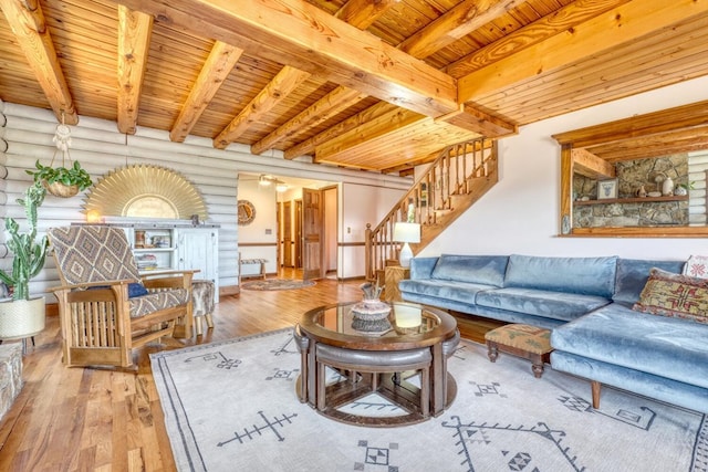 living room with beam ceiling, wood ceiling, log walls, and light hardwood / wood-style flooring