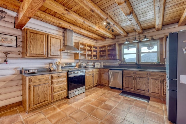 kitchen featuring rustic walls, stainless steel appliances, wall chimney range hood, beam ceiling, and wooden ceiling