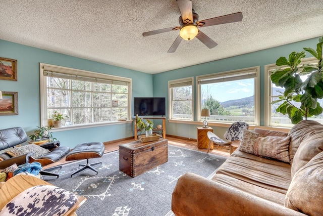 living room featuring ceiling fan and a textured ceiling