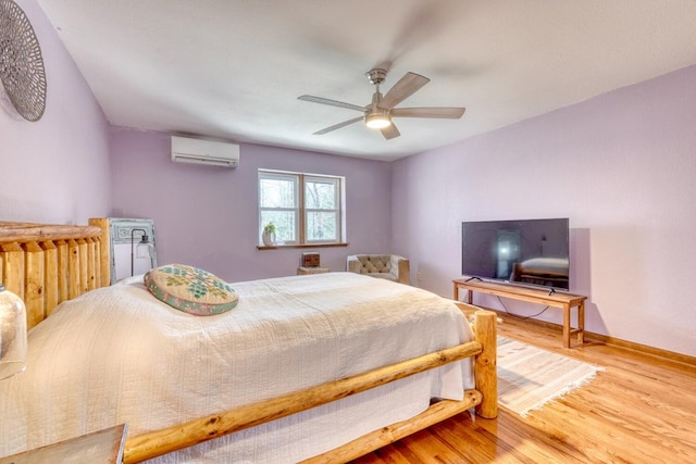 bedroom with hardwood / wood-style flooring, ceiling fan, and a wall unit AC