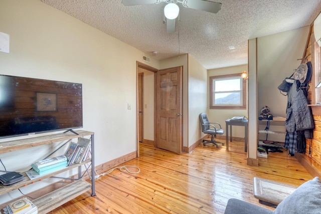 interior space with ceiling fan, light hardwood / wood-style floors, and a textured ceiling