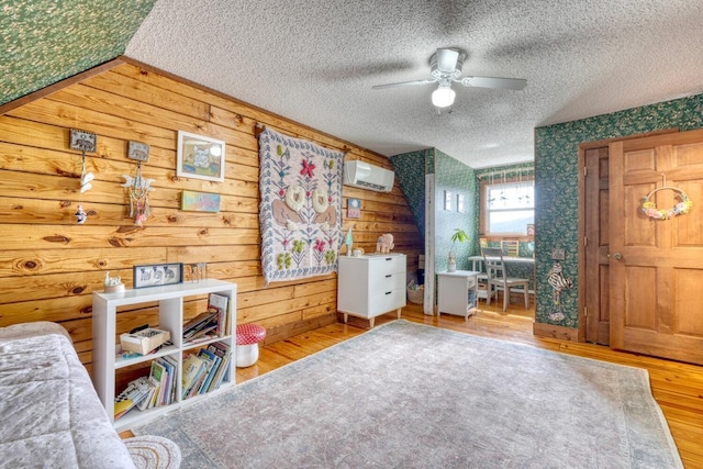 interior space featuring hardwood / wood-style floors, ceiling fan, a textured ceiling, and wooden walls