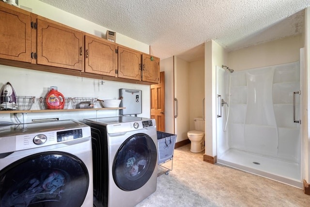 washroom with washing machine and dryer and a textured ceiling