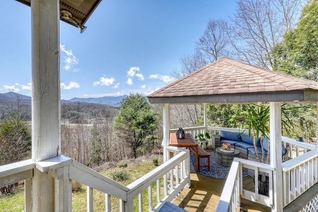 deck featuring a mountain view and an outdoor hangout area