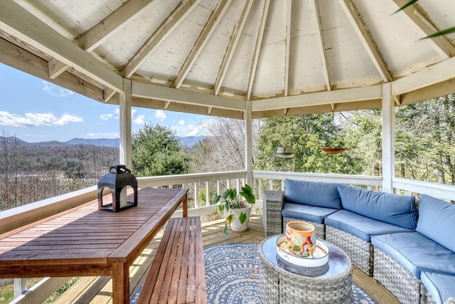 wooden terrace featuring a gazebo, a mountain view, a grill, and an outdoor hangout area