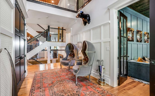 interior space with light wood-type flooring and a high ceiling