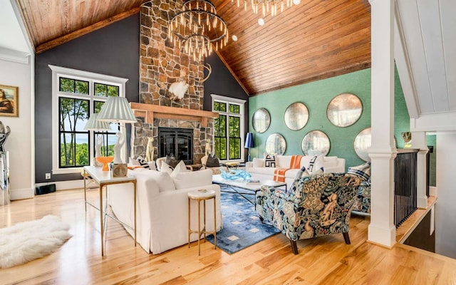 living room featuring light wood-type flooring, a notable chandelier, a stone fireplace, high vaulted ceiling, and wooden ceiling