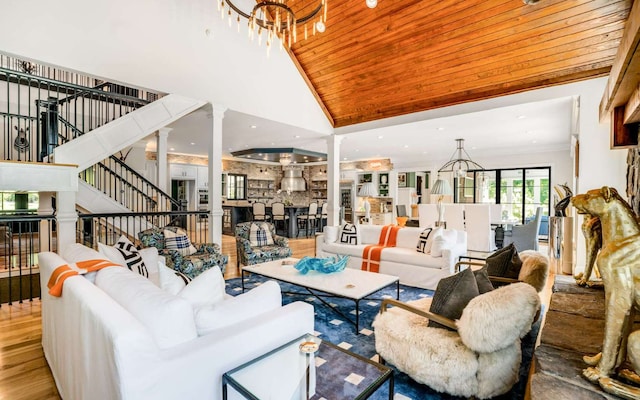 living room with hardwood / wood-style floors, decorative columns, high vaulted ceiling, a chandelier, and wooden ceiling