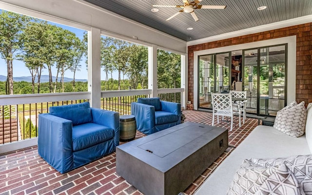 sunroom featuring a mountain view and ceiling fan