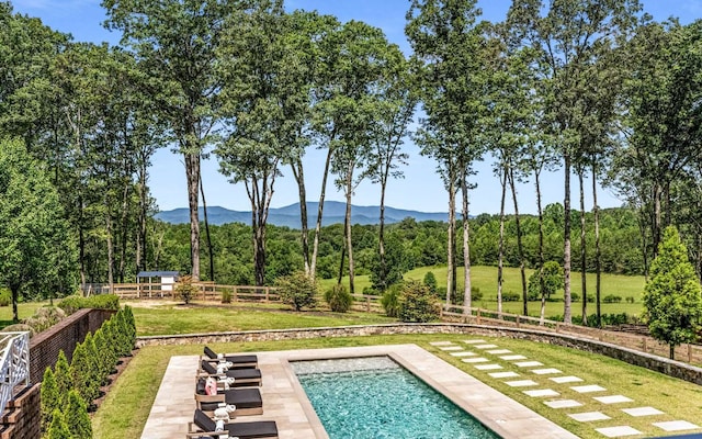 view of pool featuring a mountain view and a yard