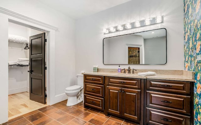 bathroom with toilet, tile floors, and vanity