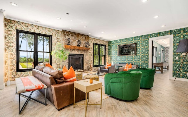 living room with plenty of natural light, french doors, light hardwood / wood-style floors, and a stone fireplace