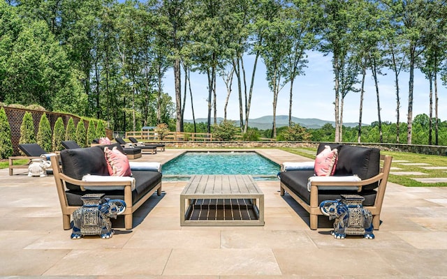 view of swimming pool featuring a patio area and a mountain view