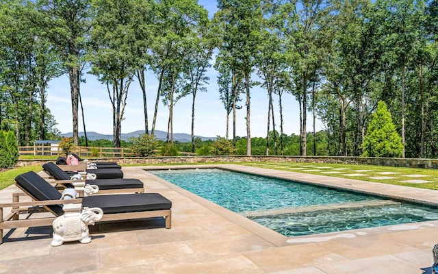 view of swimming pool with a patio and a mountain view