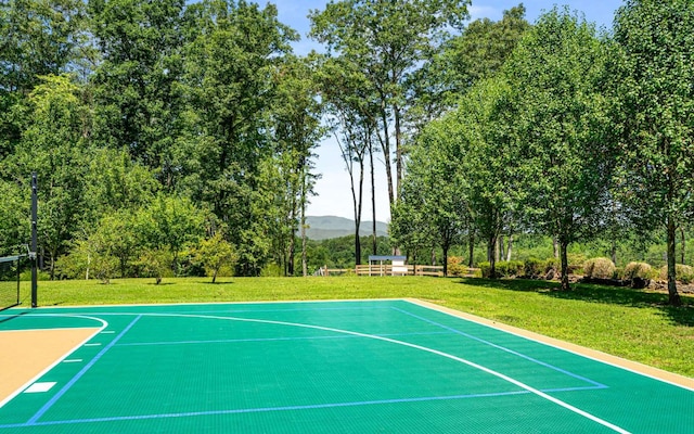 view of sport court with a lawn