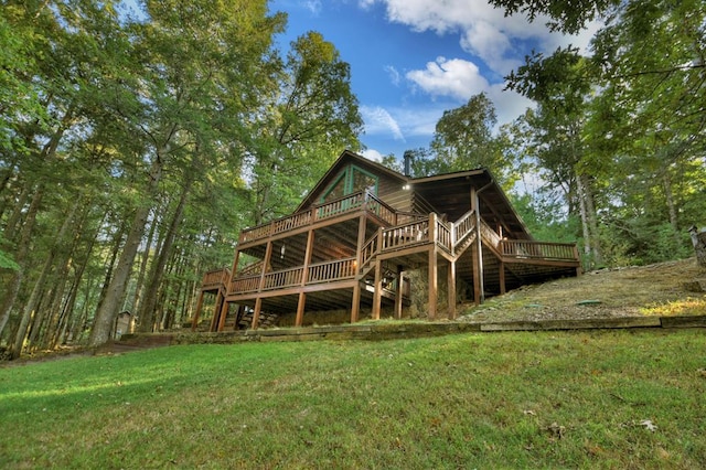 rear view of house featuring a deck and a lawn