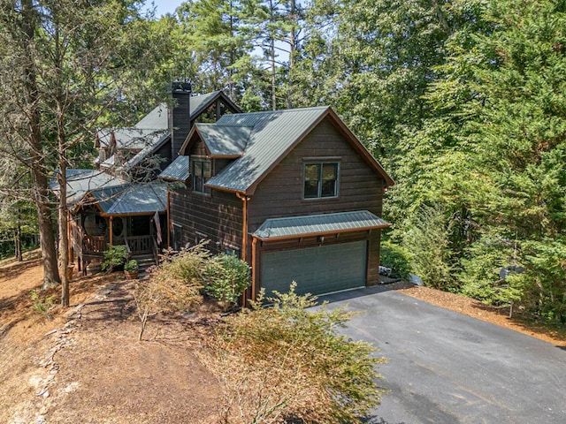 rustic home with a chimney, metal roof, and a porch