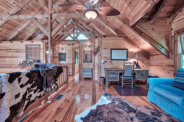 home office with light wood-type flooring, wooden ceiling, and wooden walls