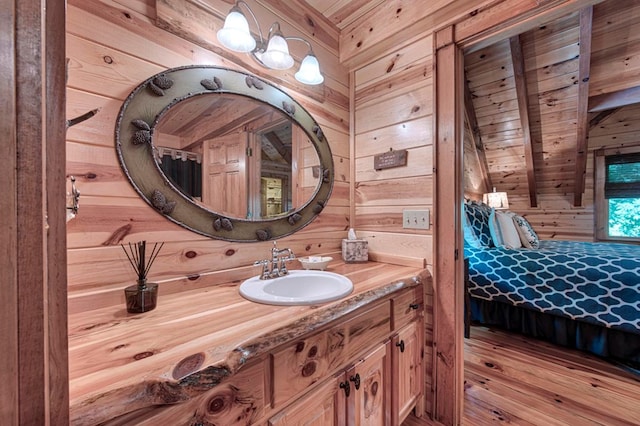 ensuite bathroom with wood walls, connected bathroom, and vanity