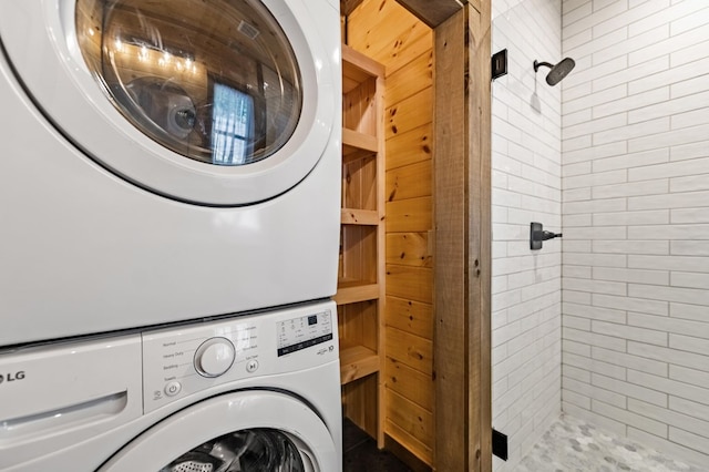 laundry room with stacked washer and clothes dryer and tile patterned floors