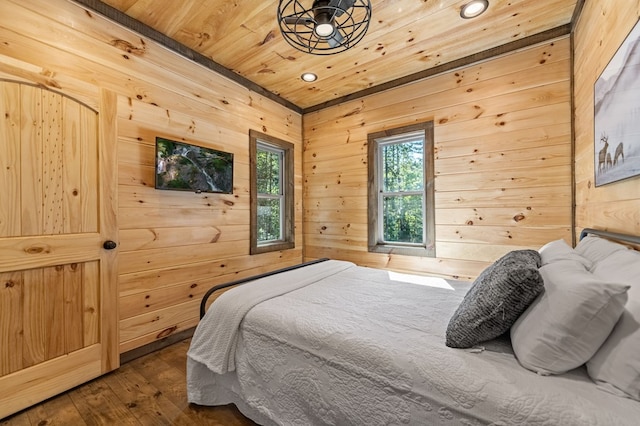 bedroom with wood-type flooring, wooden walls, and wooden ceiling