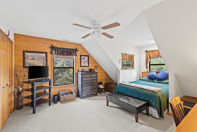 carpeted bedroom featuring ceiling fan, lofted ceiling, and wooden walls