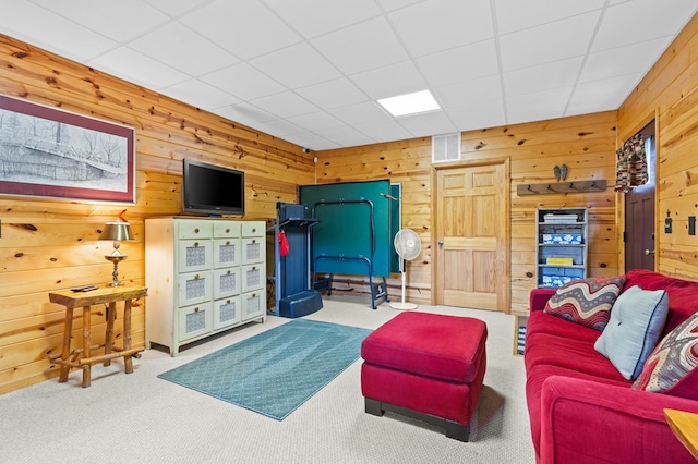 carpeted living room with wood walls