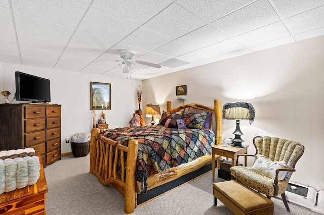 bedroom with a drop ceiling, light colored carpet, and ceiling fan