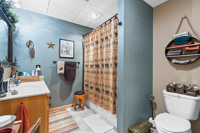 full bathroom featuring shower / bath combo, vanity, a drop ceiling, tile patterned floors, and toilet