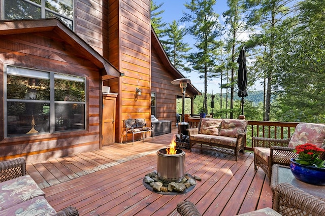 wooden deck featuring an outdoor living space with a fire pit